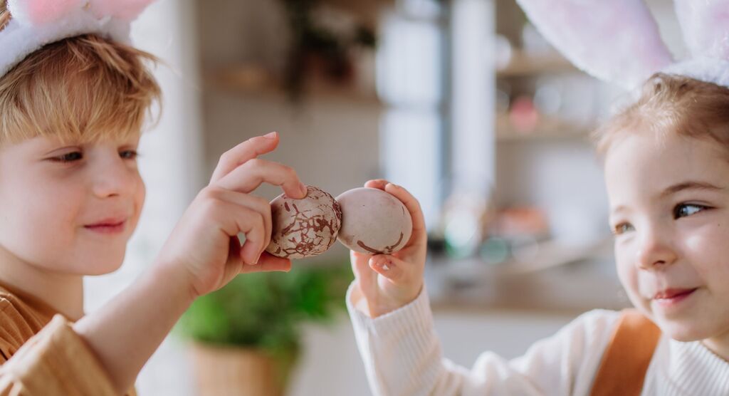 Dos niños jugando con dos huevos de Pascua en Semana Santa.