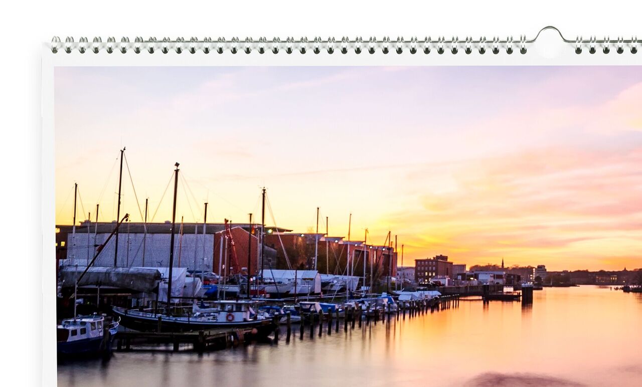 Un hermoso atardecer sobre un puerto con barcos. El cielo brilla en cálidos colores.