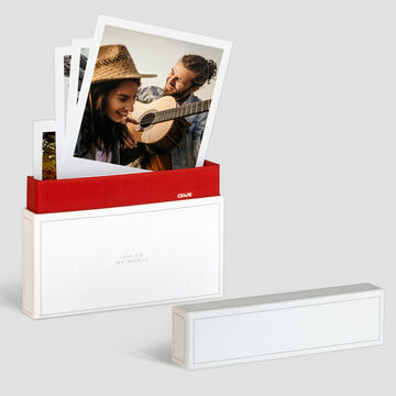 Una hermosa pila de fotos de CEWE en una caja creativa. Algunas fotos muestran amigos tocando música.