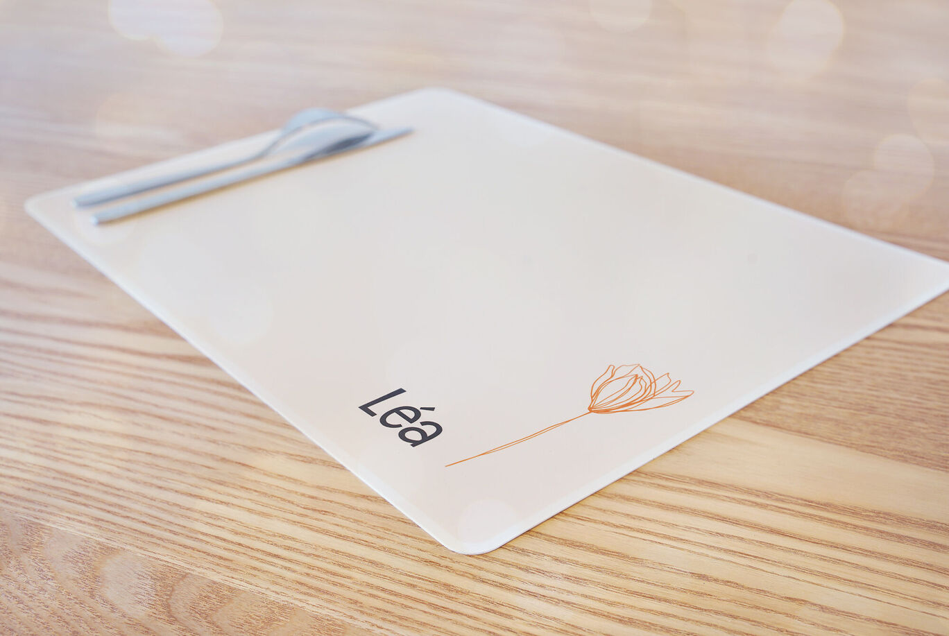 Mesa decorada con un mantel. El mantel dice 'Léa' y tiene una flor.