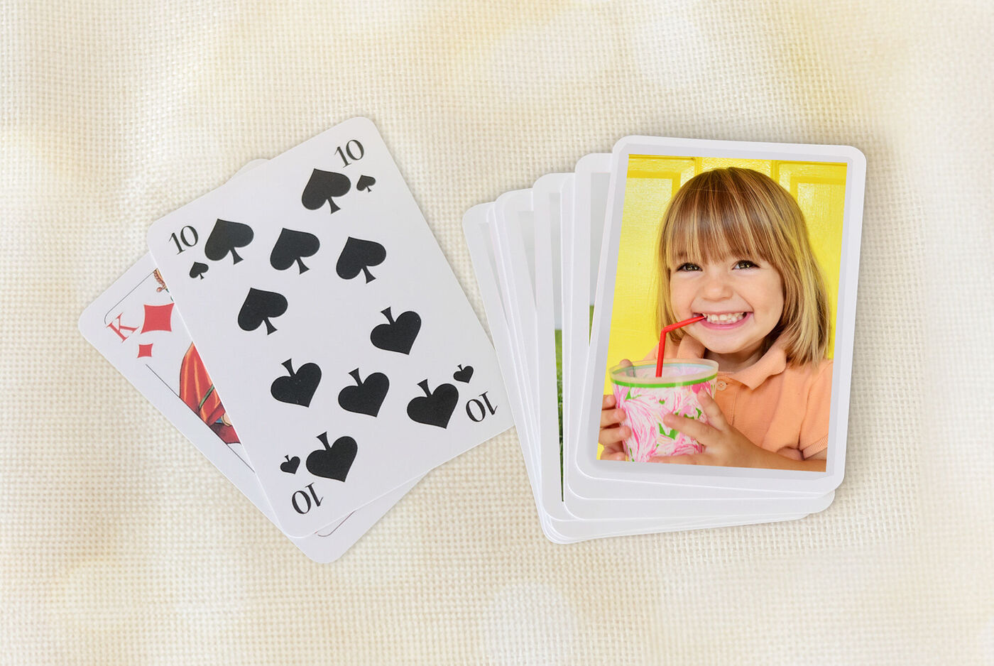 Dos cartas de juego y un montón de fotos de un niño sosteniendo una bebida.