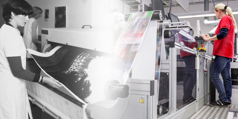 Una empleada enrolla un gran cartel en la impresora. El proceso de impresión está en curso.