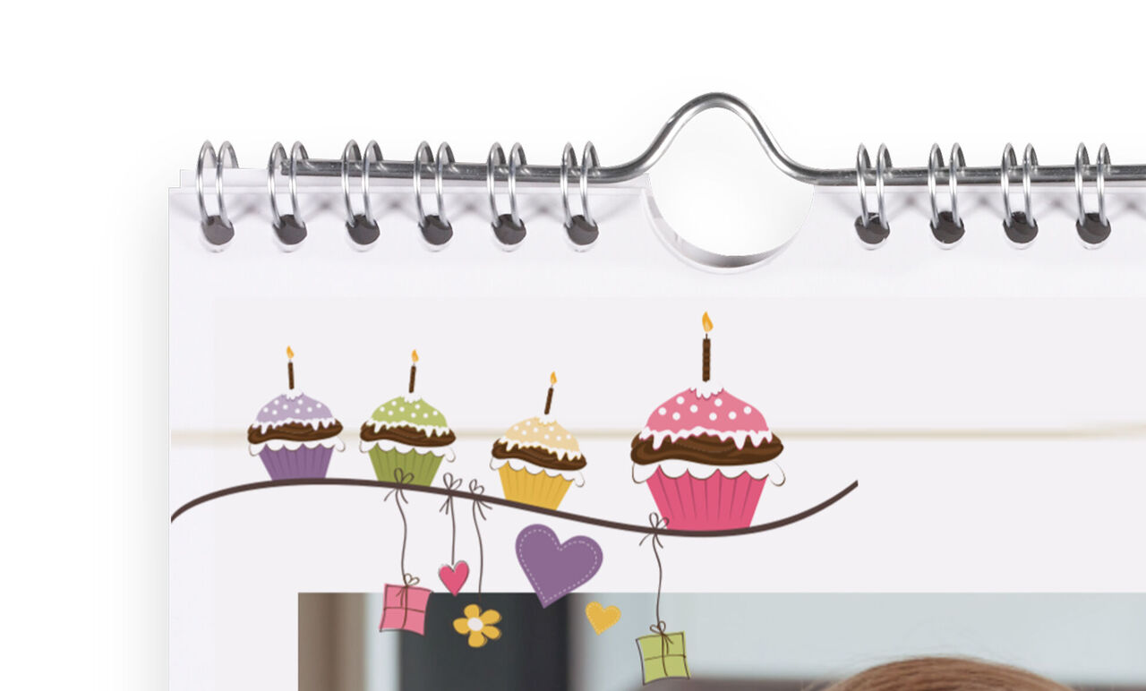 Coloridos cupcakes con velas sobre un cuaderno.