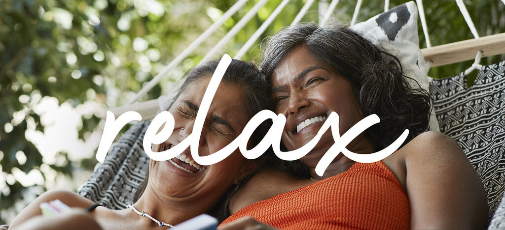 Dos personas descansan en una hamaca al aire libre