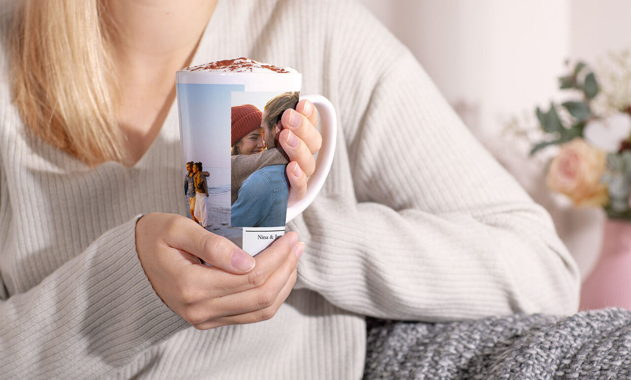 Una persona sostiene una taza personalizada con fotos de bonitos recuerdos.