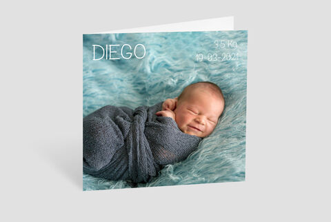 Bebé recién nacido en manta gris sobre fondo suave turquesa