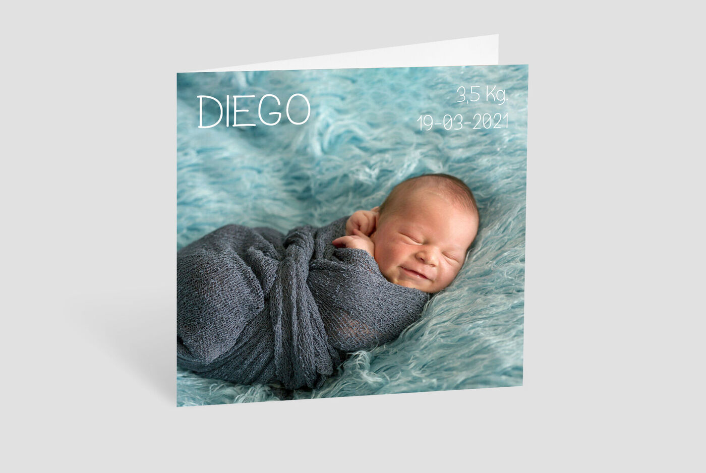 Bebé recién nacido en manta gris sobre fondo suave turquesa