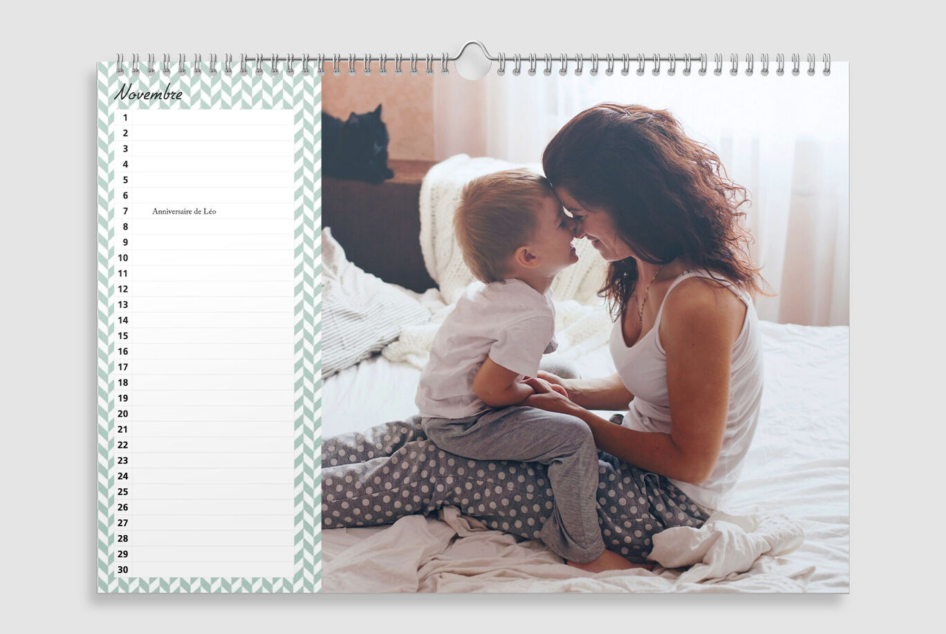 Una madre abraza a su hijo en la cama con luz del día de una ventana.