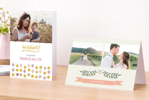 Dos bellas invitaciones sobre una mesa, una con un corazón y otra con diseño floral.