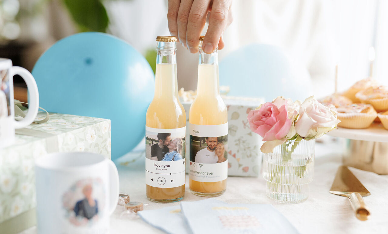 Dos botellas en una mesa de fiesta con una etiqueta personalizada impresa y pegada.