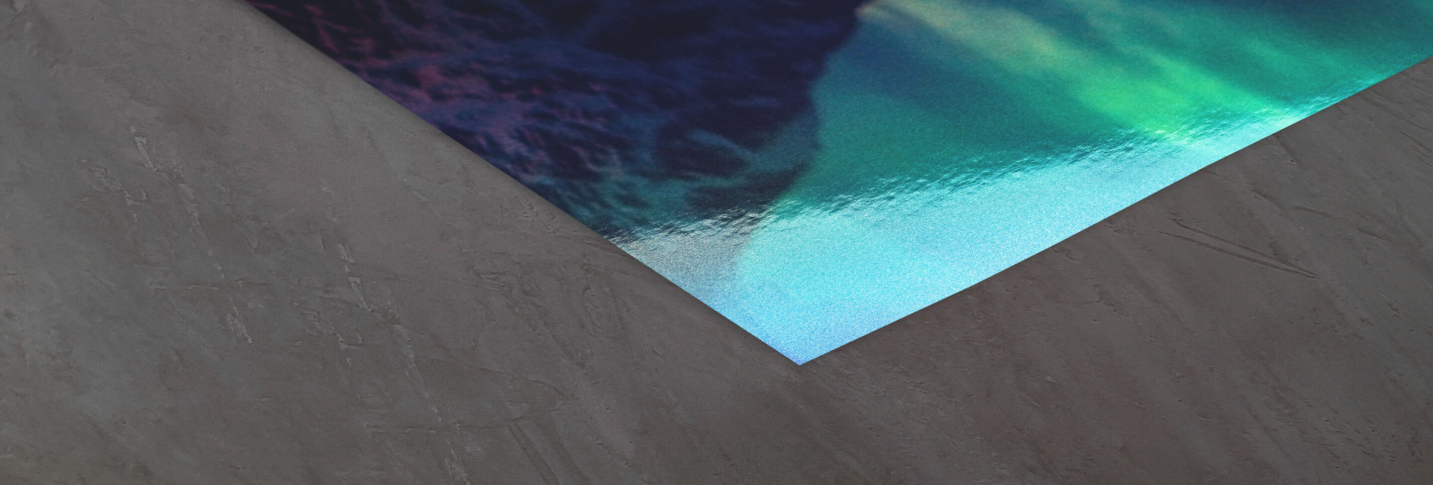 Esquina de un póster brillante con motivo de olas sobre fondo gris.