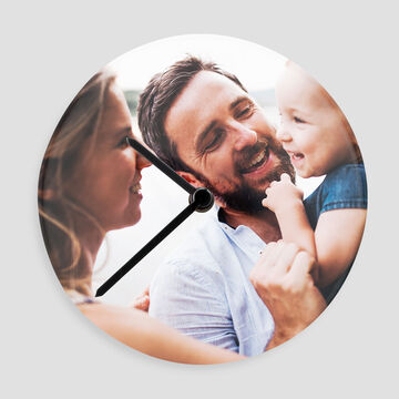 Una feliz familia usa un reloj de pared creativo para recordar momentos especiales.