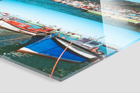 Barcos coloridos en aguas claras, con sol y cielo azul de fondo