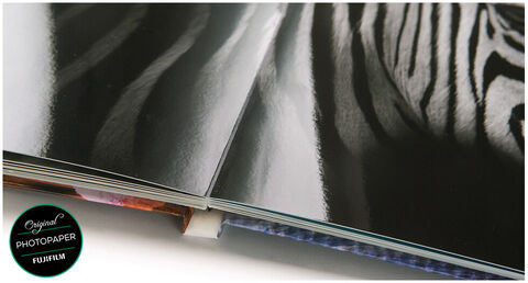 Página abierta de un Fotobuch CEWE con imágenes definidas y una hoja negra