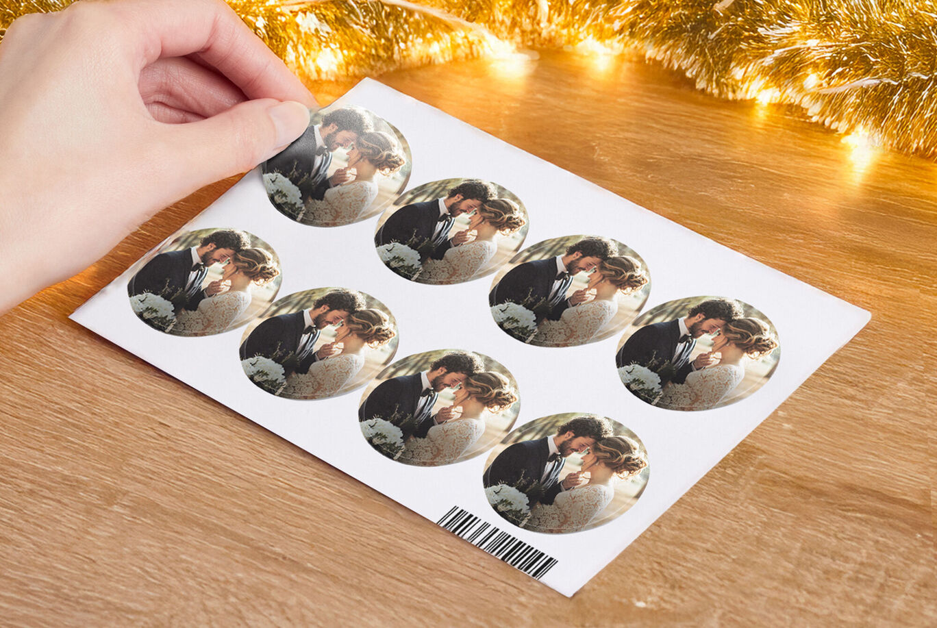 Una mano sostiene una hoja con siete pegatinas redondas que muestran una pareja abrazándose.