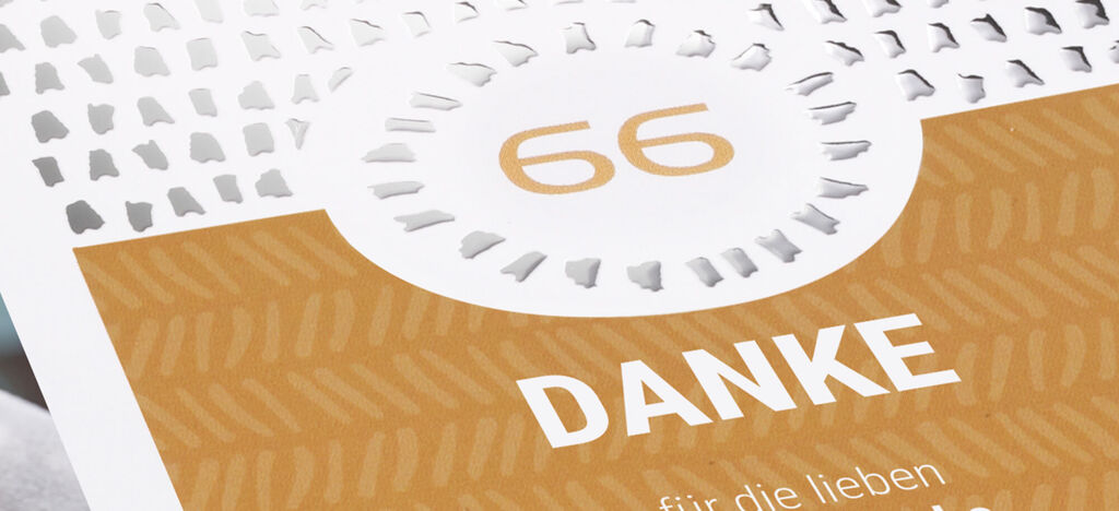 Un modelo de tarjeta de CEWE con el número 66 y el texto 'GRACIAS' sobre fondo marrón claro