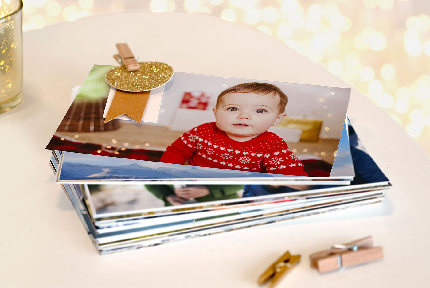Fotos clásicas reveladas en una mesa. También hay unas pinzas para decorar la casa en Navidad.