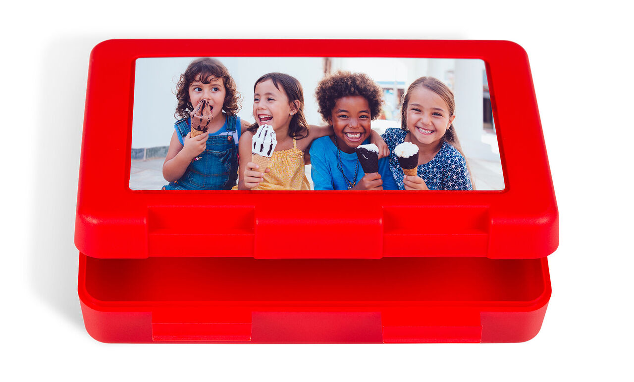 Caja roja con foto de niños felices comiendo helado.