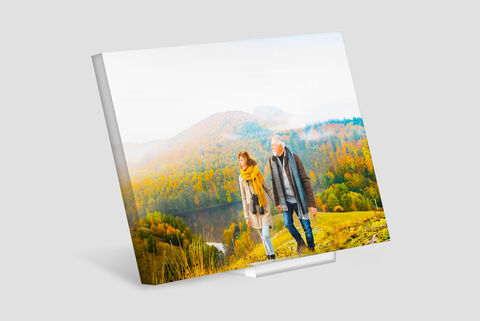 Una pareja feliz en un paseo por la naturaleza con árboles de colores en otoño.