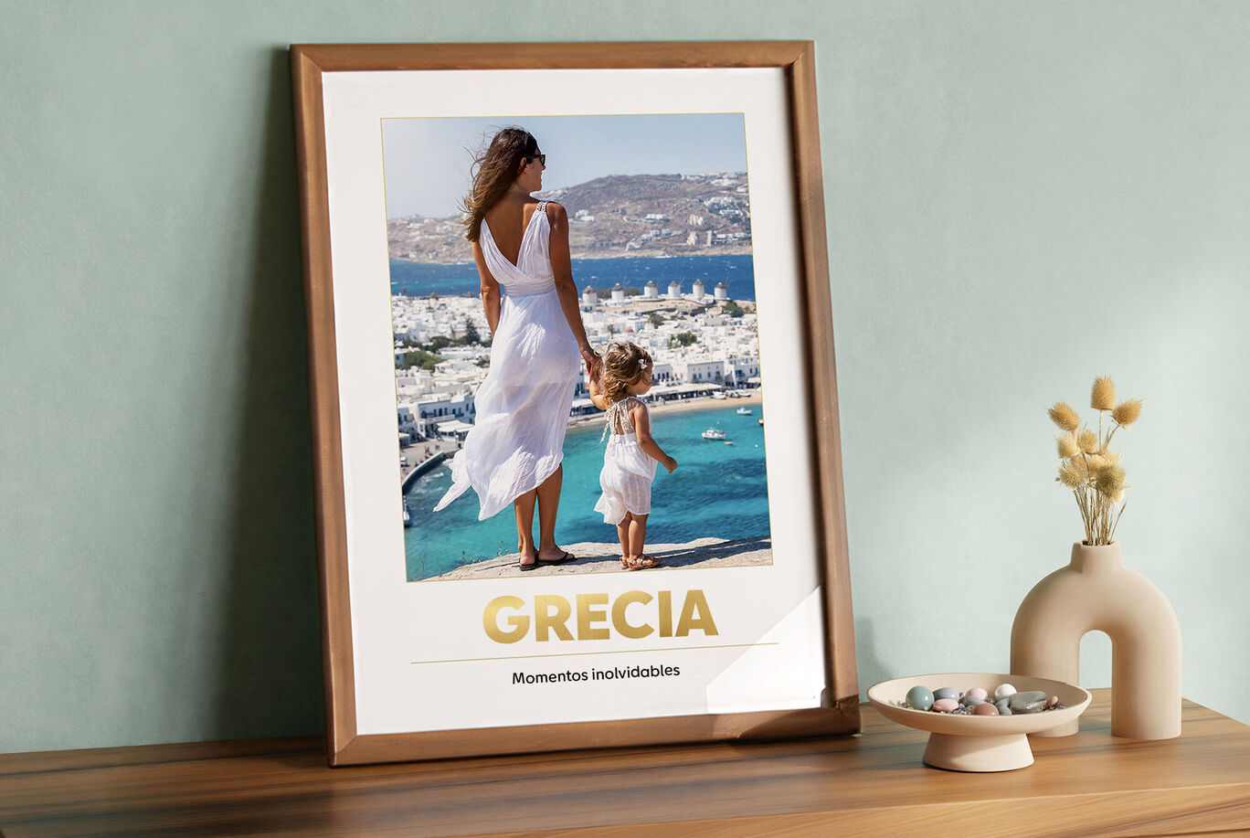 Una madre y su hija juntas frente a una vista costera impresionante en Grecia. La madre lleva un vestido blanco.