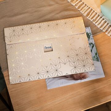 Una caja de regalo CEWE FOTOBUCH empaquetada sobre una mesa.