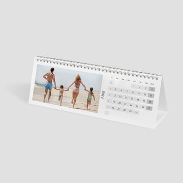 Familia camina por la playa de la mano, un momento feliz en el calendario
