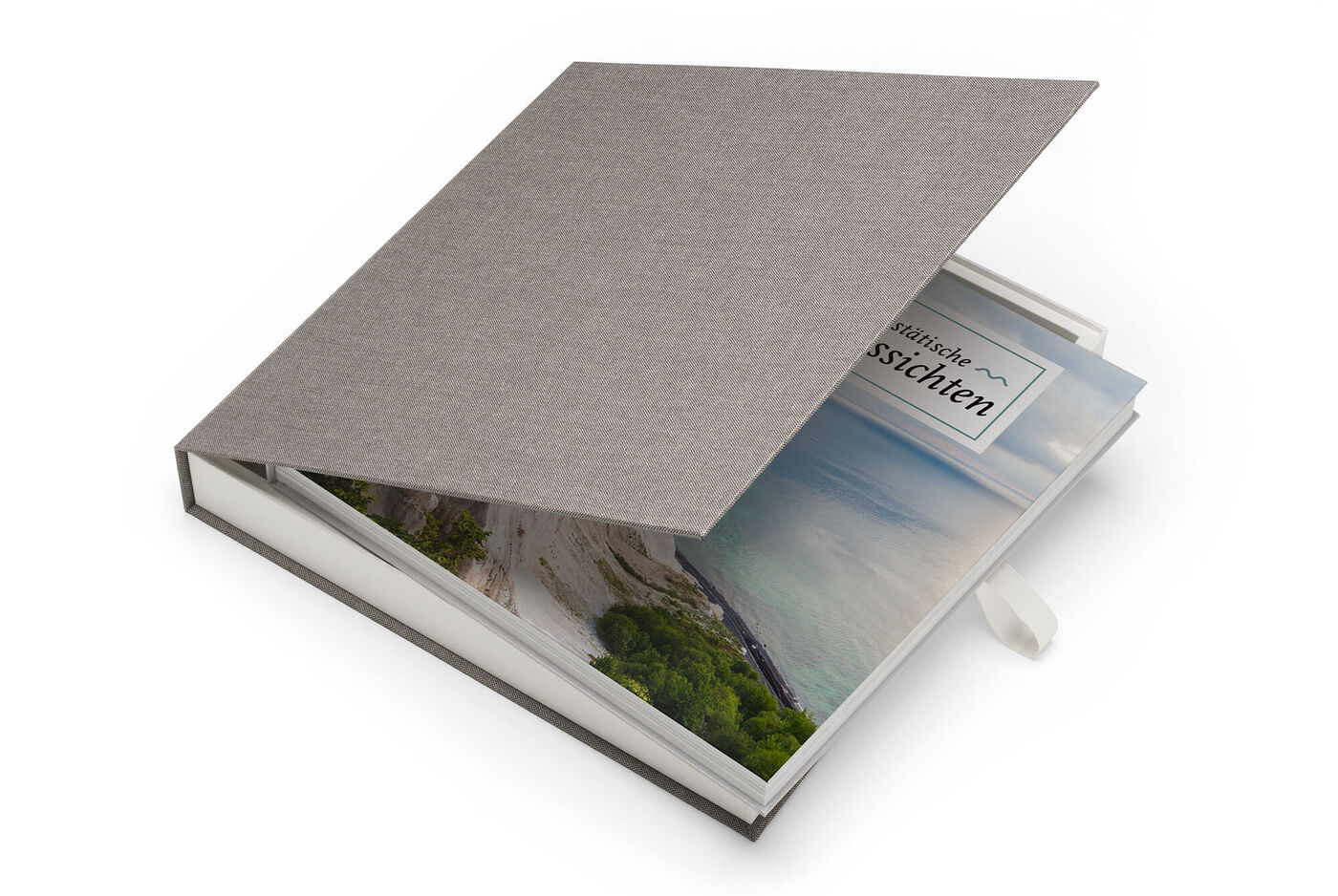 Un elegante CEWE FOTOBUCH con encuadernación de tela gris y ventanita muestra una colorida foto de paisaje.