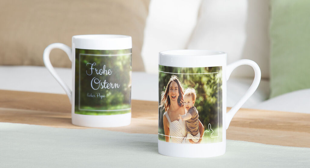 Dos tazas alegres con diseños de Pascua sobre una mesa