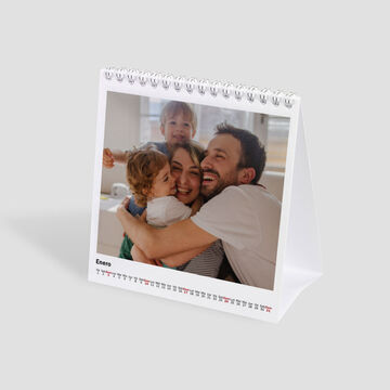 Un creativo calendario de mesa con fotos de niños y adultos felices.