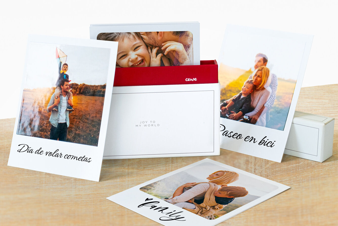 Tres tarjetas CEWE con fotos cariñosas de la vida familiar en una mesa.