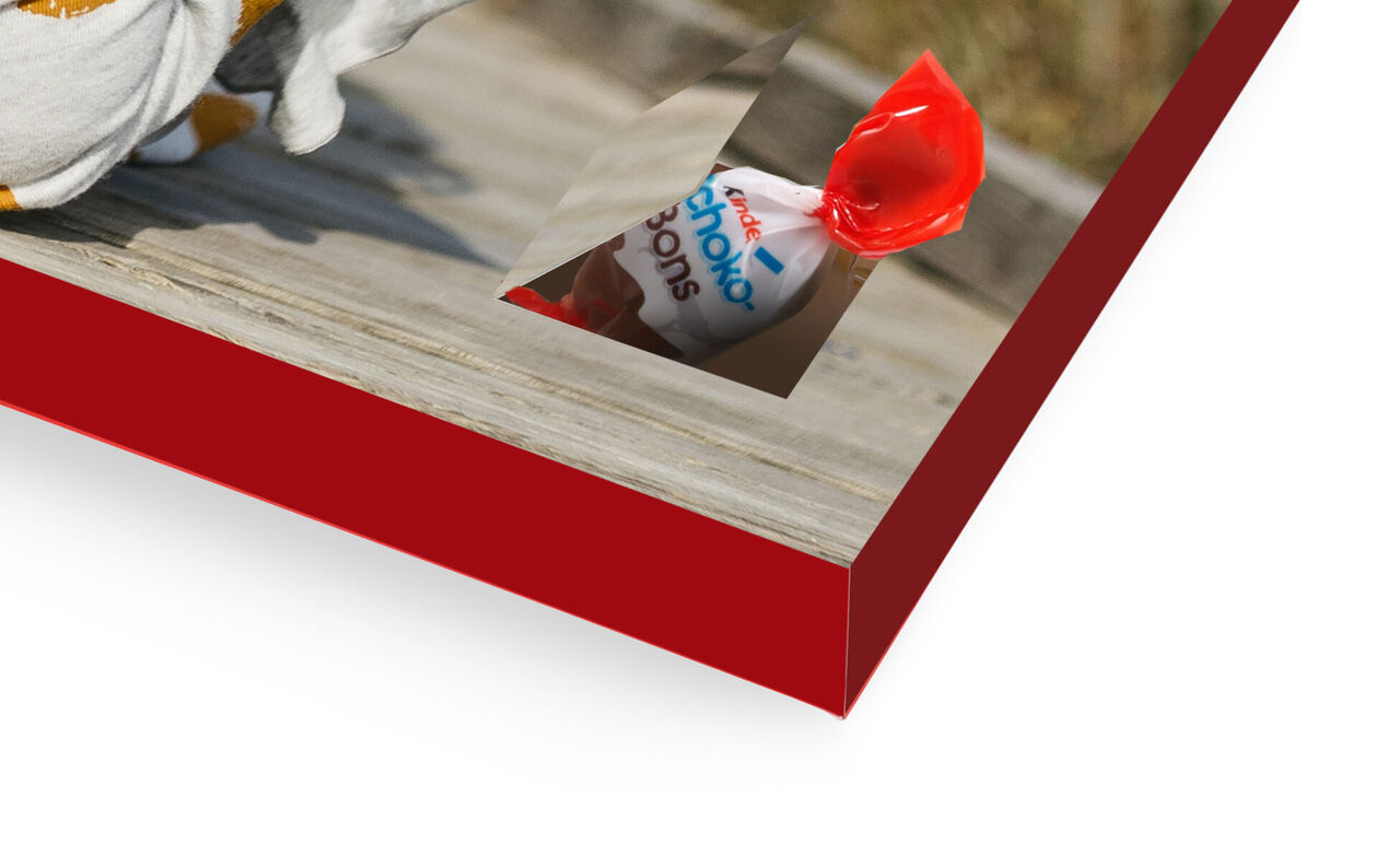 Vista detallada de una pintura de pared roja con un pequeño regalo sobre ella.