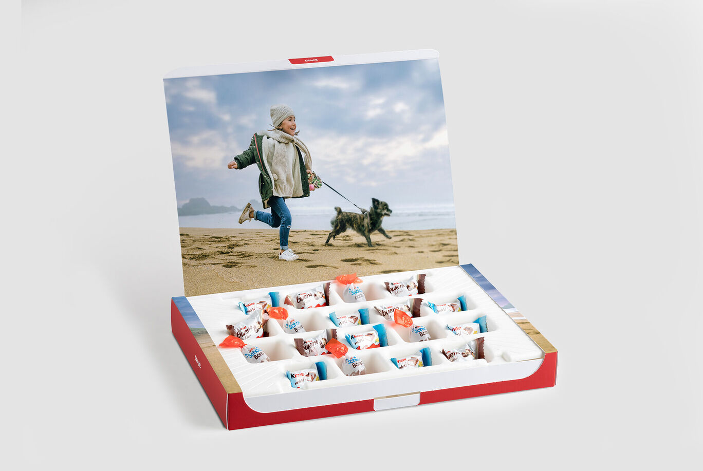 Un niño corre felizmente en la playa con un perro.