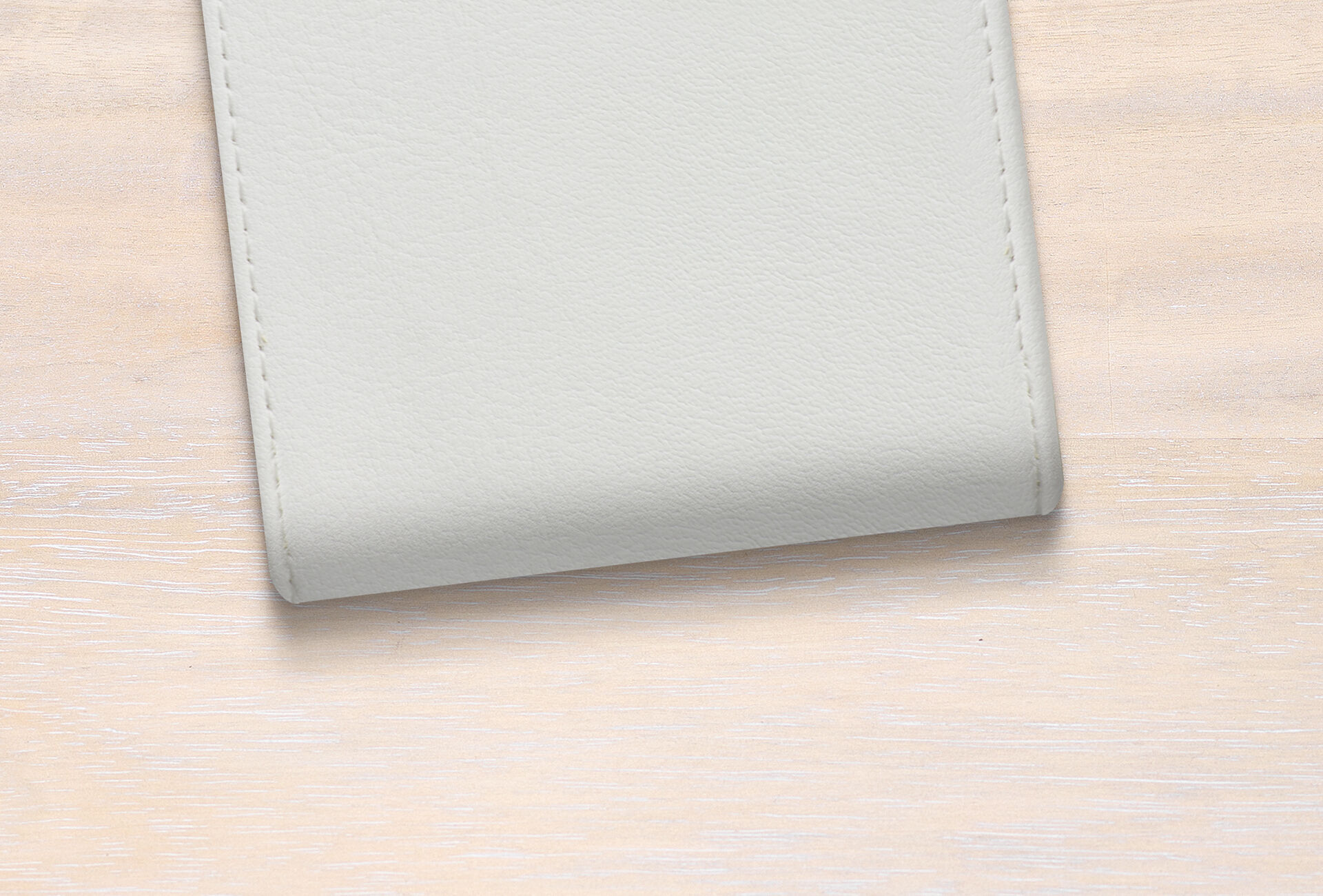 Funda de álbum fotográfico elegante y clara sobre una mesa de color madera.