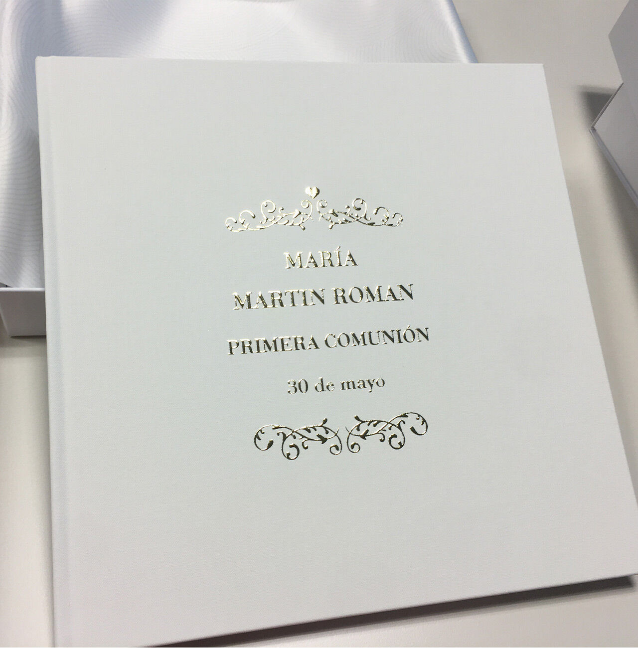Un álbum blanco con letras doradas titulado "Maria Martin Roman" y la fecha "30 de mayo".