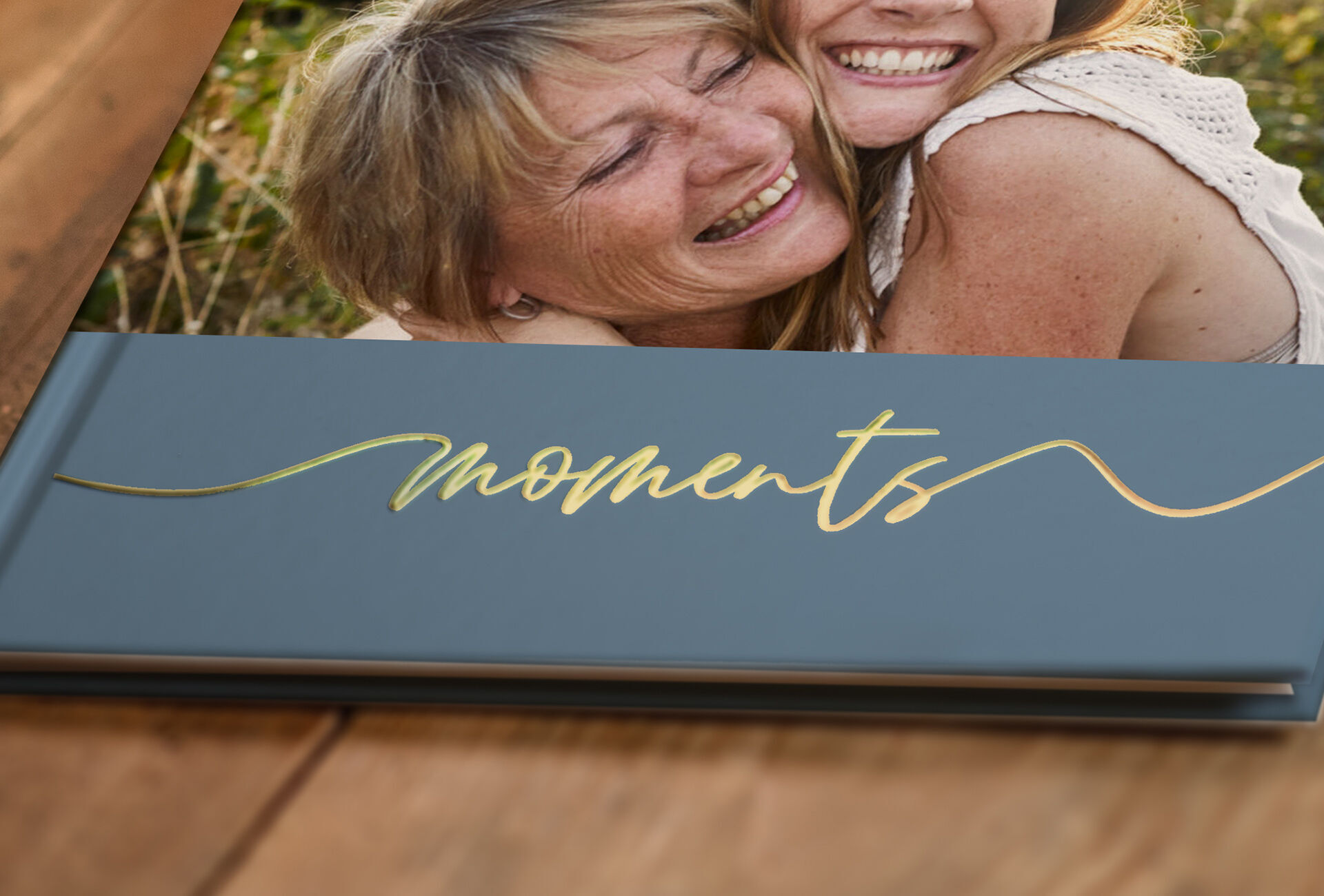 Un elegante álbum de fotos con escritura dorada que muestra la palabra 'Moments'.