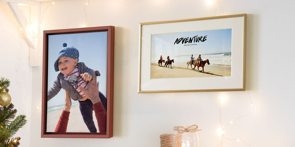Un niño feliz es levantado por una persona mientras un cuadro de una aventura en la playa cuelga al lado