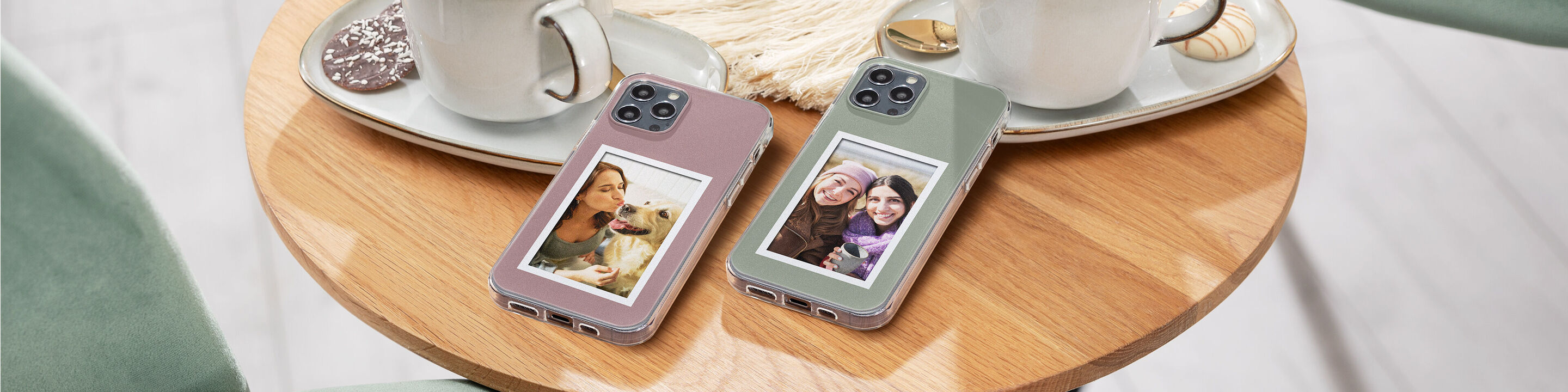 Dos fundas de teléfono con fotos de momentos felices sobre una mesa con tazas.
