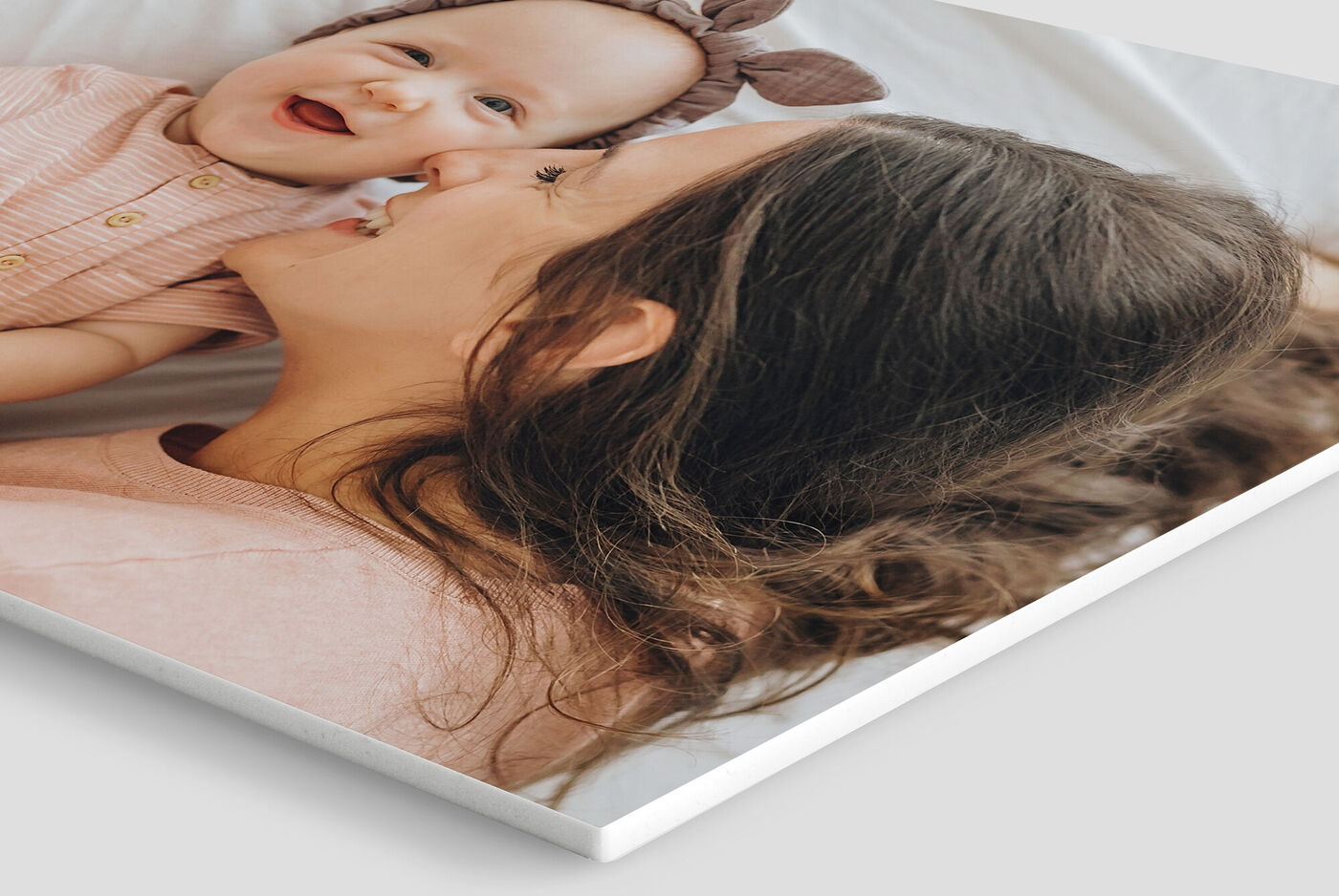 Madre sonriente con un niño pequeño en su regazo, ambos felices y enamorados.