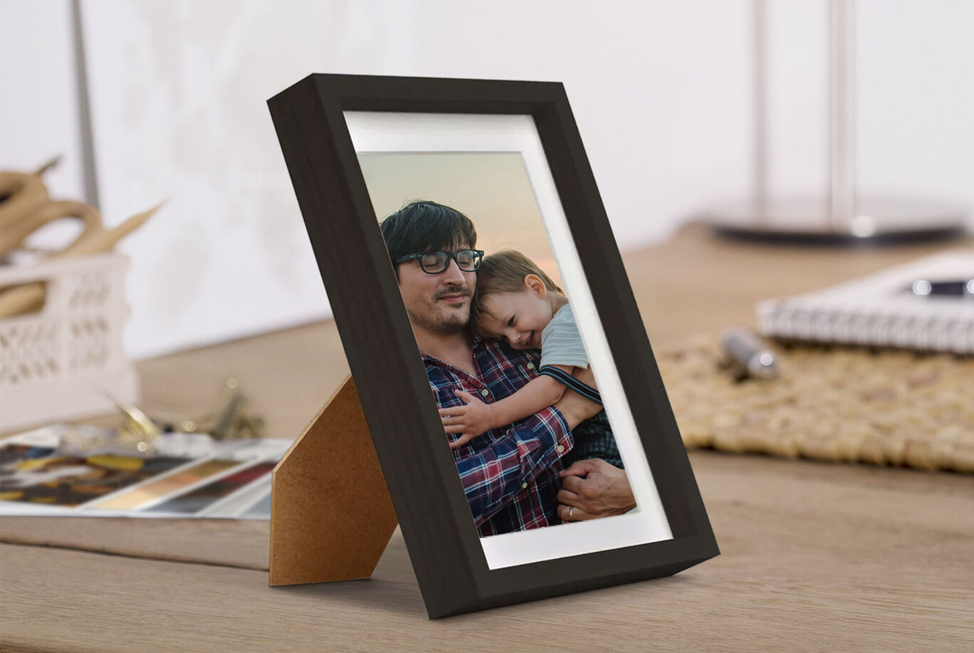 Una foto amorosa en un marco negro que muestra a un padre con su hijo. Irradia alegría y cercanía.