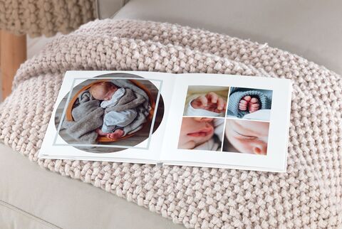 Un álbum de fotos abierto sobre una manta clara. Muestra imágenes de un recién nacido en varias poses.
