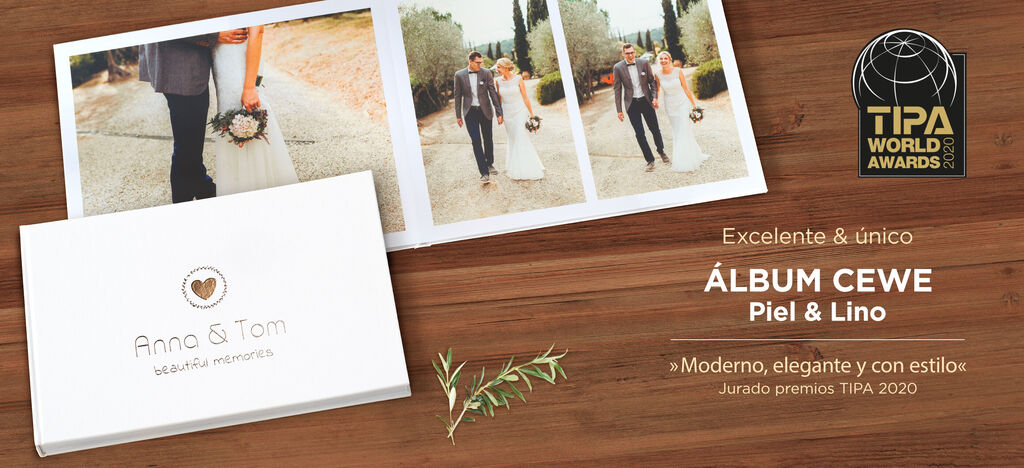 Un libro fotográfico CEWE en una mesa de madera, rodeado de naturaleza, mostrando fotos de una pareja de novios.