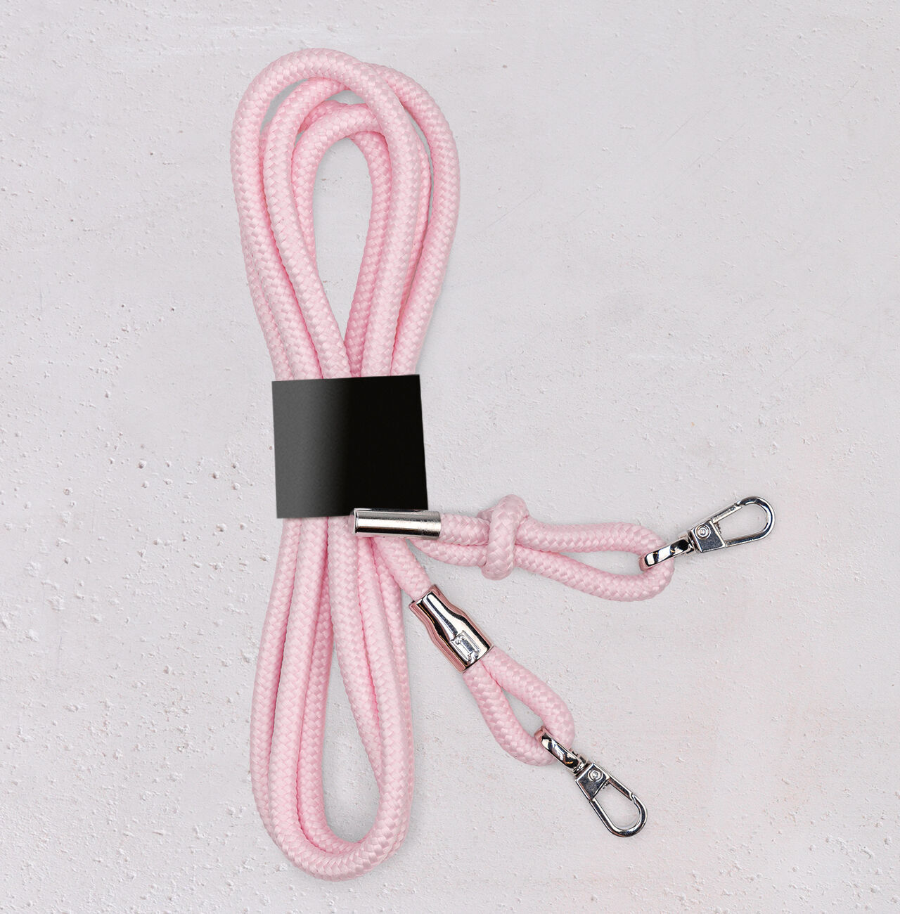 Cuerda Trekkö en rosa, con cierres plateados, bien ordenada sobre un fondo claro.