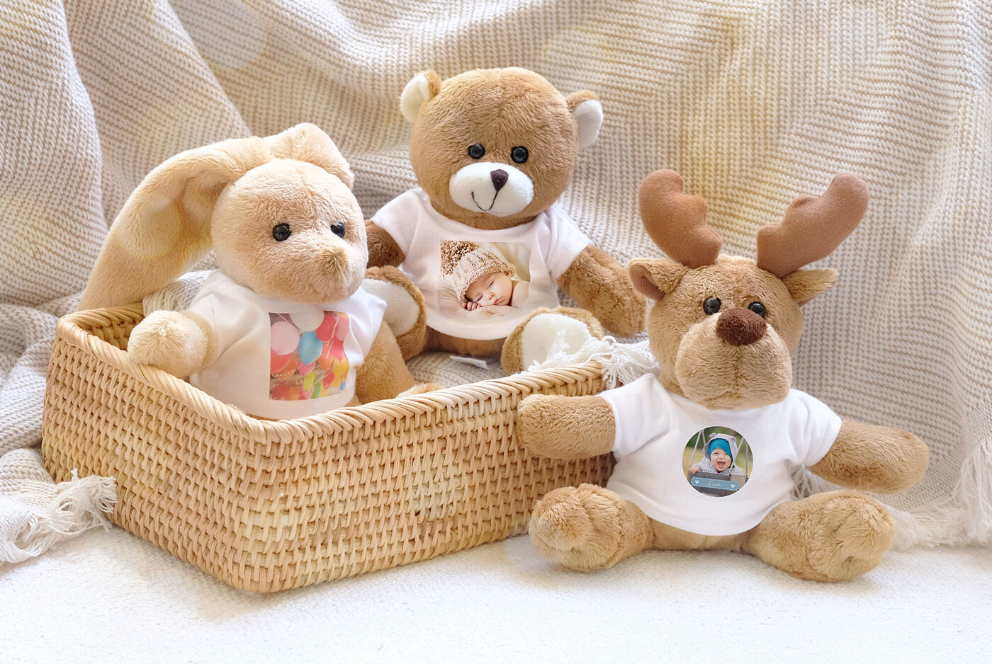 Tres peluches acogedores en una cesta de mimbre, cada uno con una foto en una camiseta, transmitiendo alegría.
