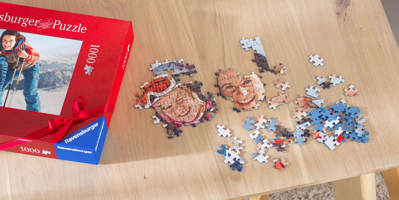 Puzzle Ravensburger personalizado de 1000 piezas hecho por partes en una mesa con la caja incluida.