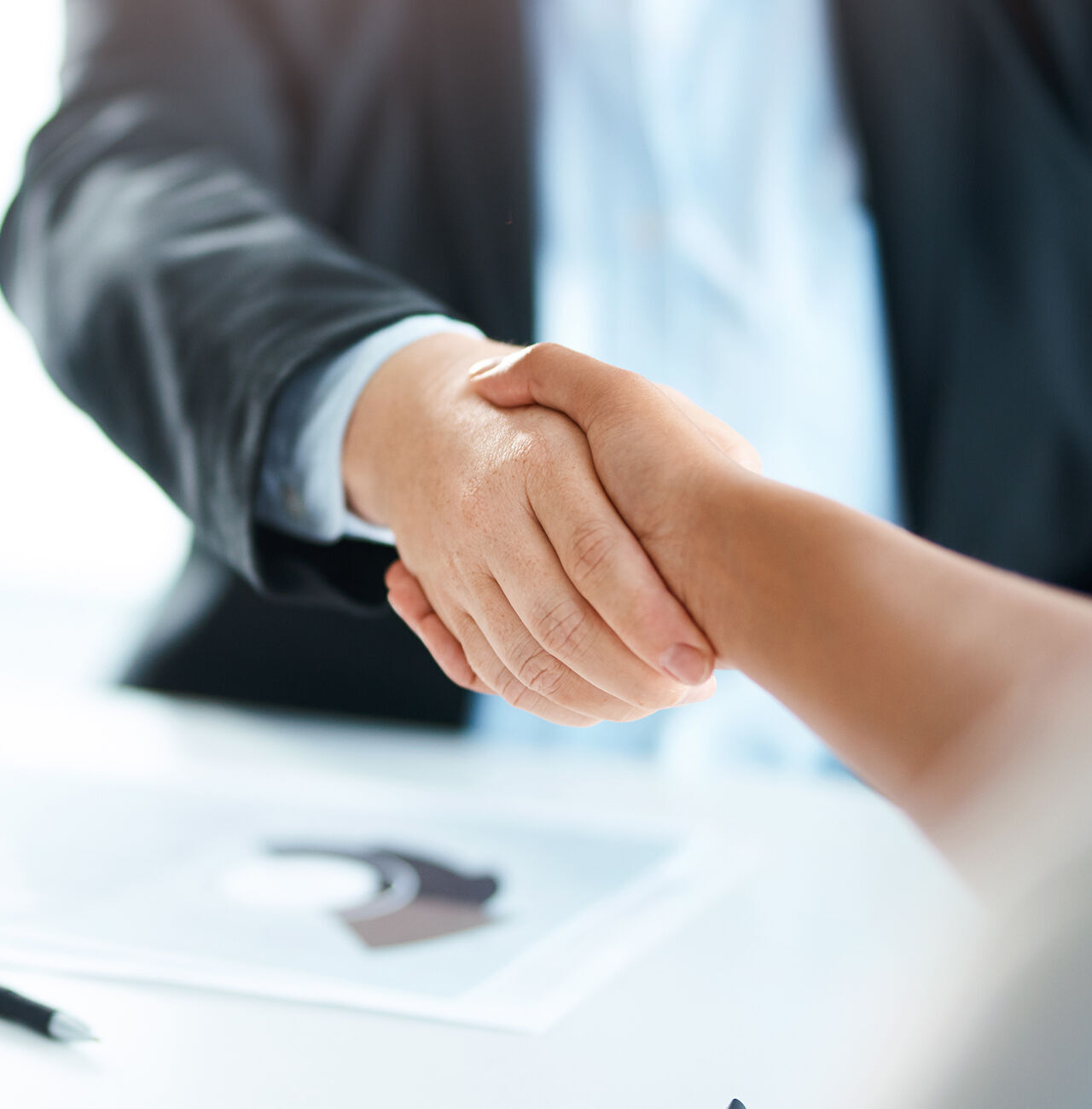 Dos personas se dan la mano en un saludo en una situación de negocios.