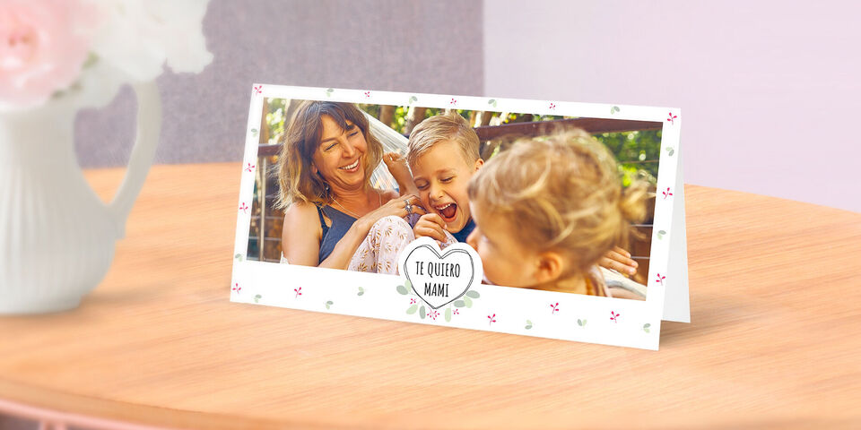 Tarjeta amorosa con el texto 'TE QUIERO MAMÁ' rodeada de flores.