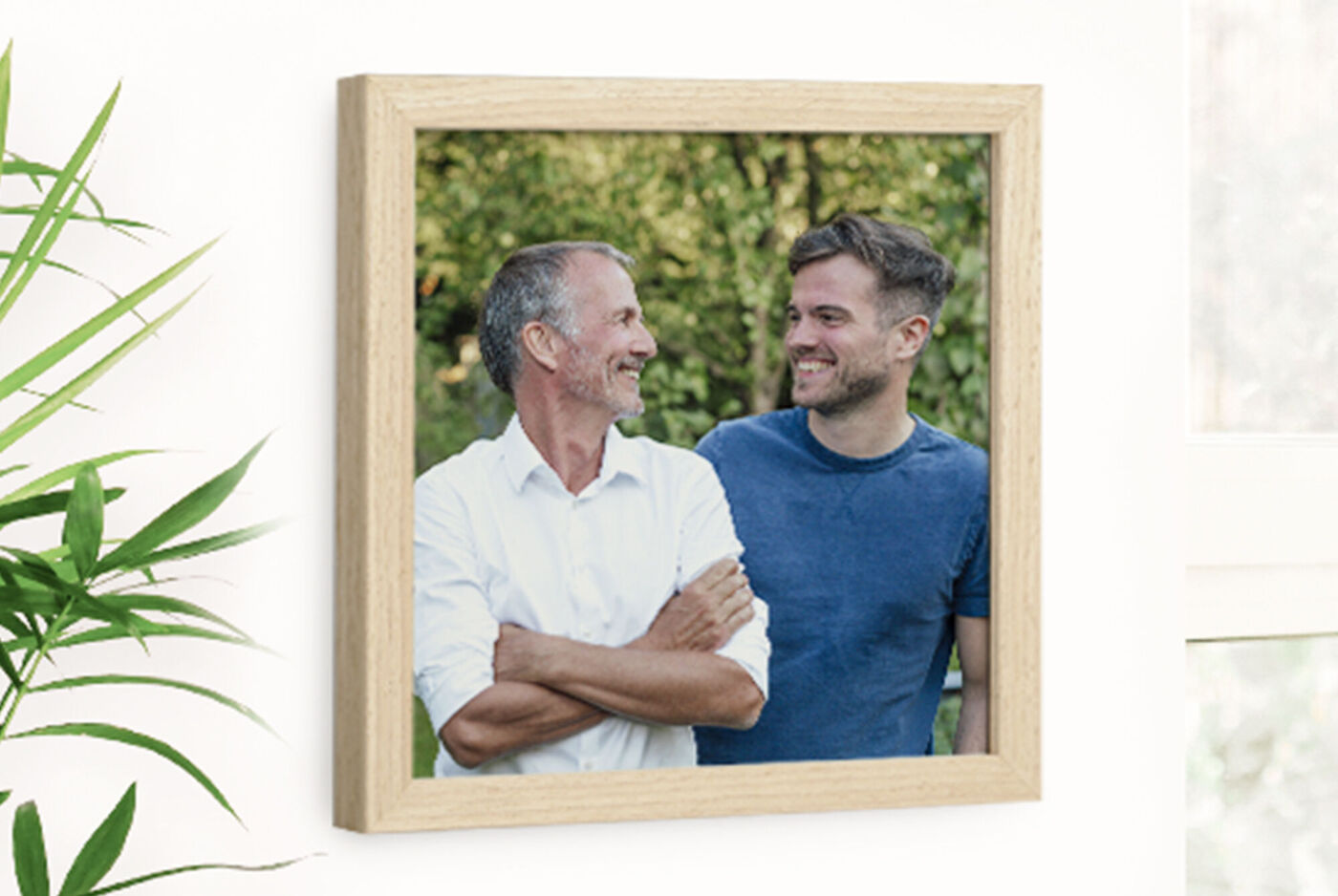 Dos hombres de pie juntos, sonriendo y disfrutando al aire libre.