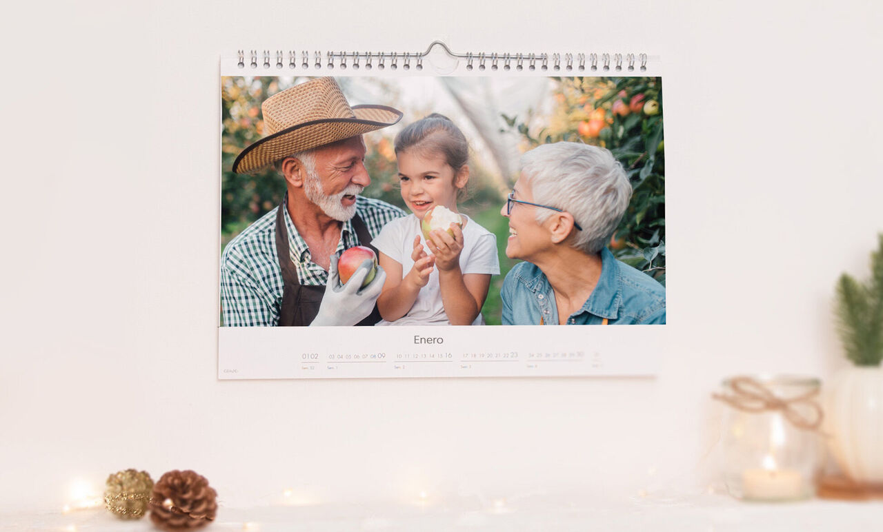 Un momento feliz en el calendario con tres personas en un campo sosteniendo manzanas