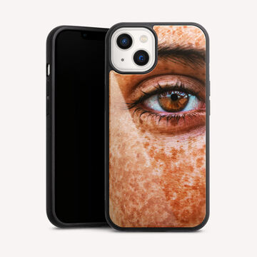 Primer plano de un ojo con pecas, con luz reflejada en él.