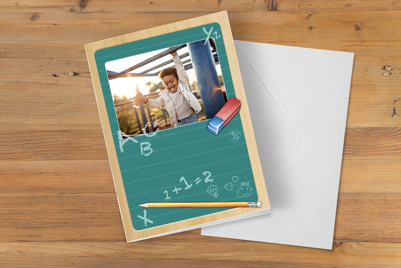Tarjeta de felicitación divertida con una foto de un niño sonriente, rodeada de útiles escolares y un fondo de pizarra verde.